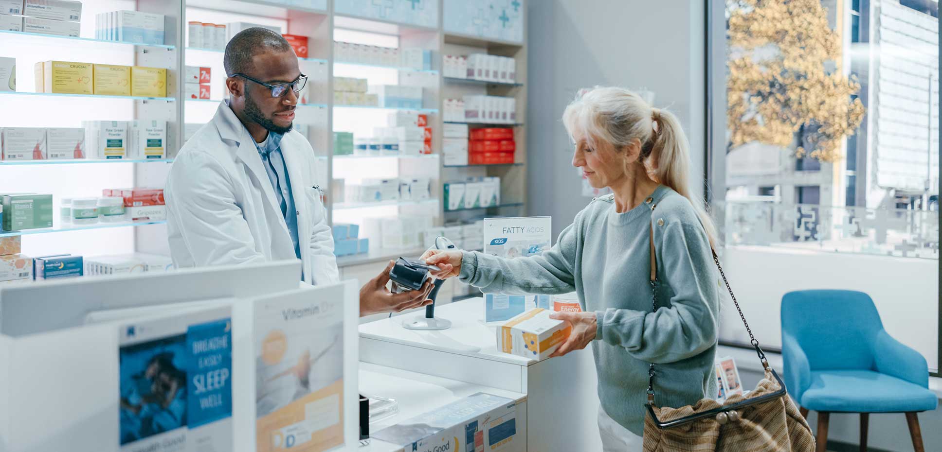 Woman paying for prescription at pharmacy counter