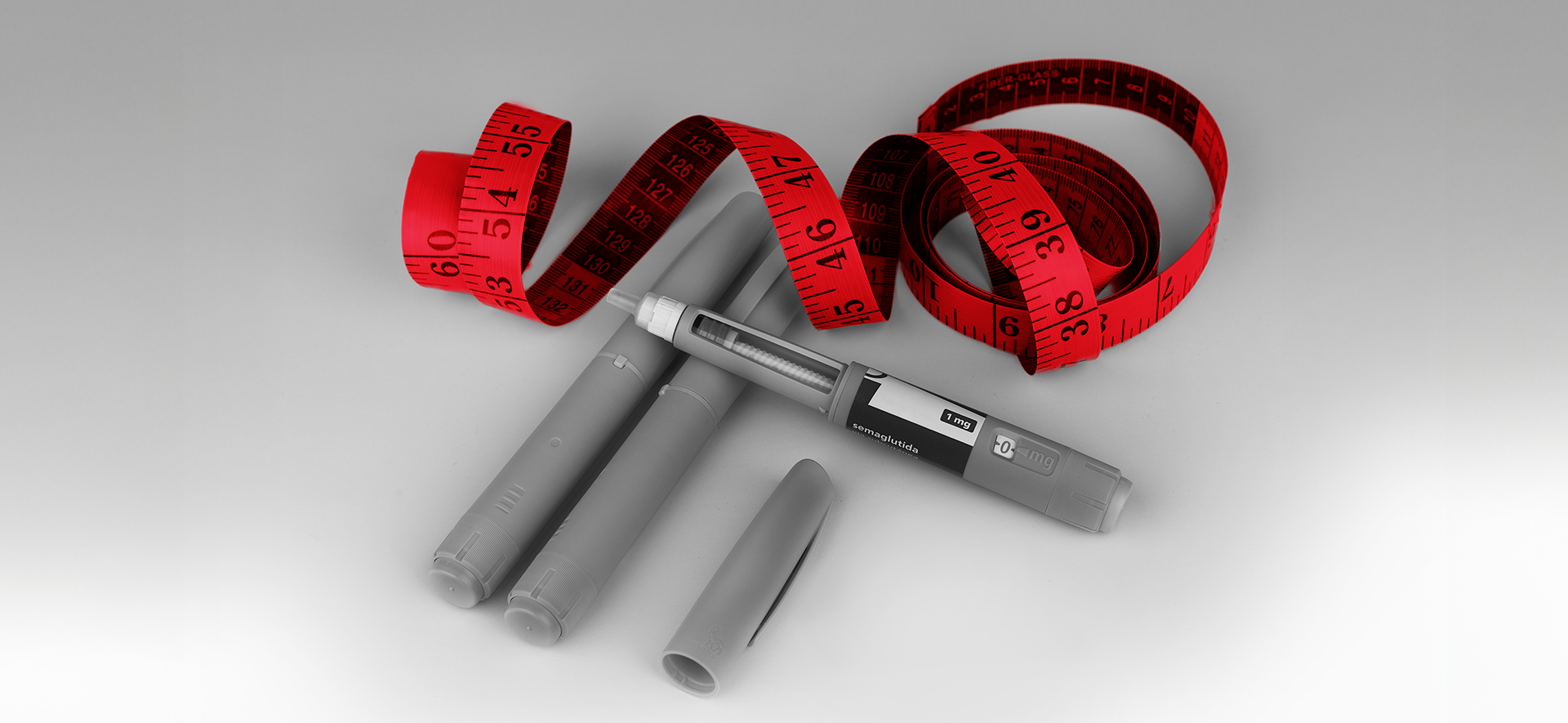A bold red tape measure wraps around vials of a GLP-1 drug