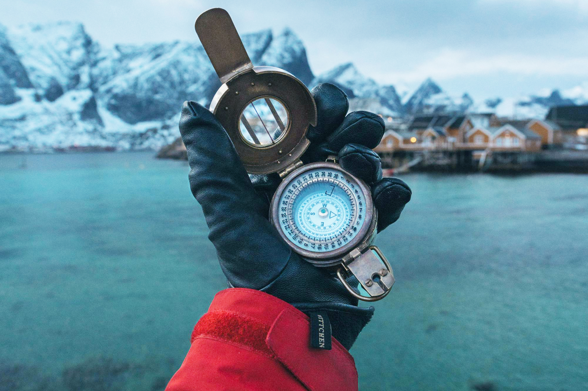 A hand holds a compass