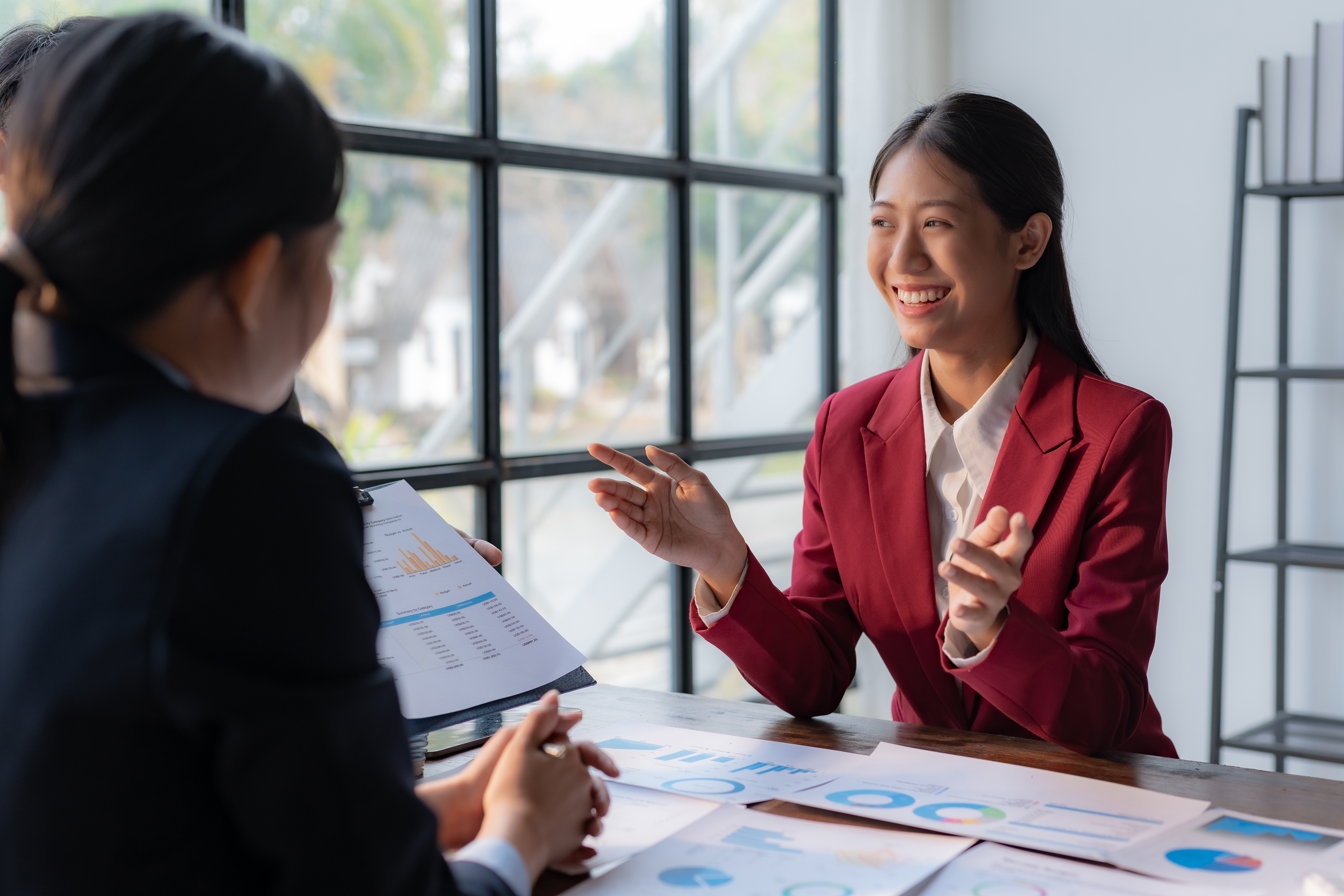 "Two professionals weigh a single figure together — the disciplined judgment that keeps capital both compliant and free to move."