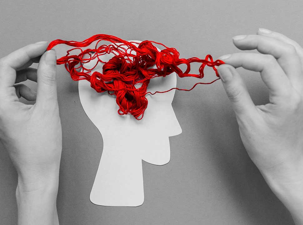 A tangled set of yarn sits atop a silhouette of a head, representing cognitive decline
