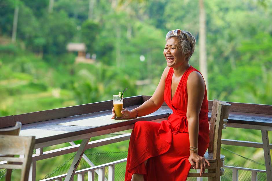 An asian retiree laughs in a vacation spot