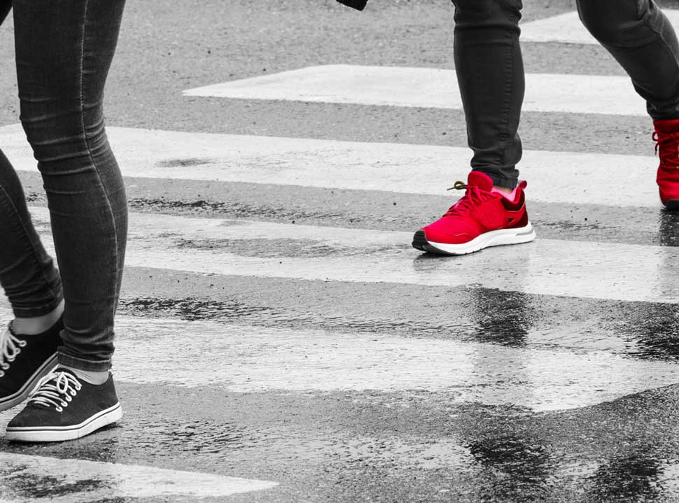 Individuals pass a busy crosswalk, representing population trends
