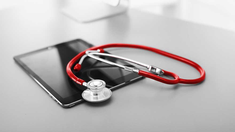 Laptop with health dashboard and stethoscope