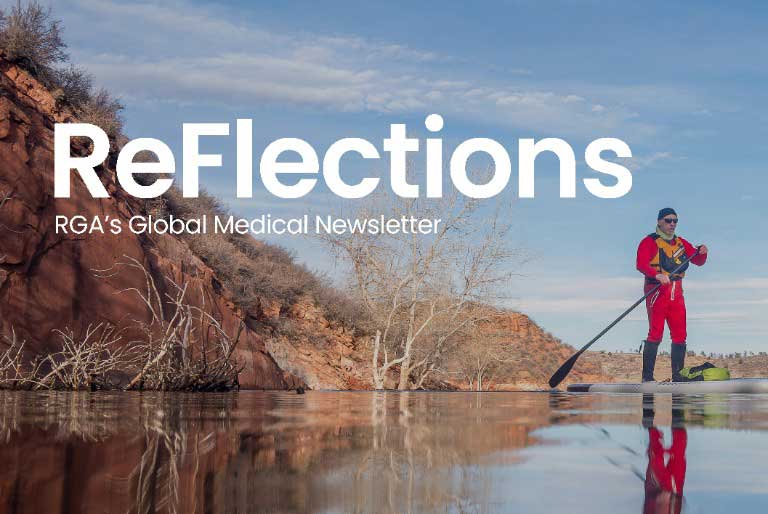 A kayaker in a red slicker paddles through a reflective pond