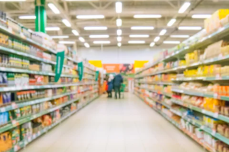 Blurred shoppers peruse supermarket shelves
