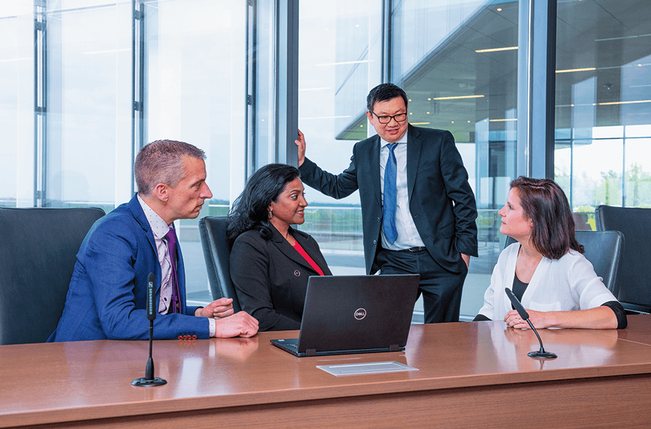 A group of EMEA financial executives gather around a laptop