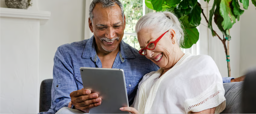 An older couple navigating a tablet together — the ongoing service behind a pension transfer