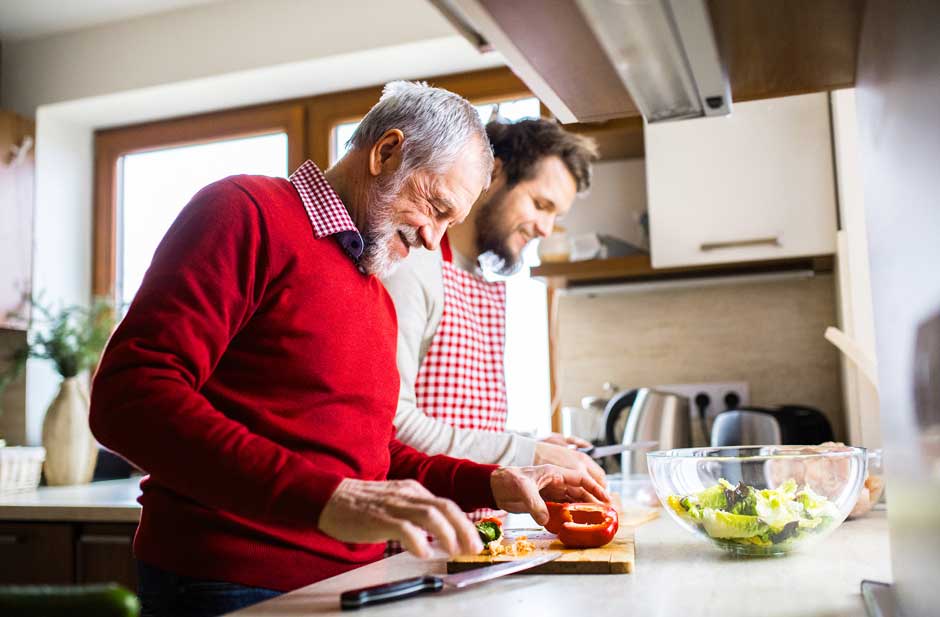 A father and son cooking together — the everyday security behind a pension promise.