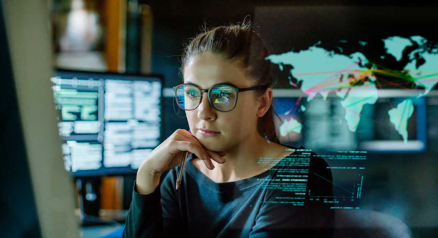 A woman gazes intently at rows of code