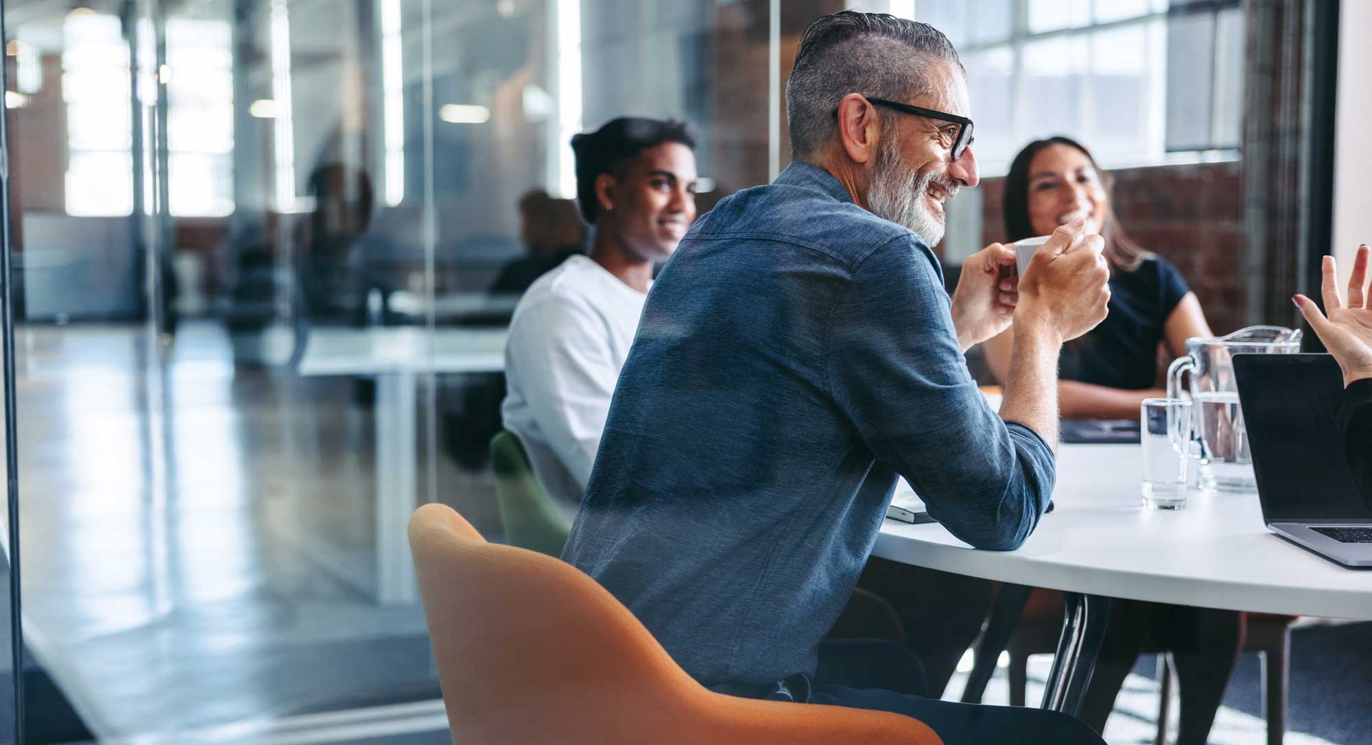 A group of colleagues meet in an office for conversation