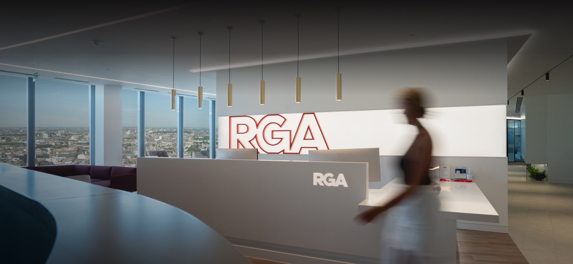 A blurred figure passes by the RGA logo