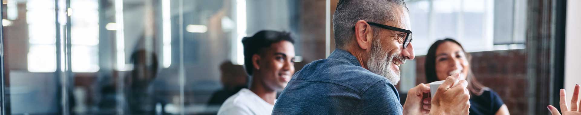 A group in conversation in a glasswalled office