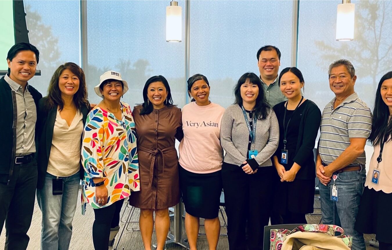 Members of an Employee Resource Group celebrating Asian heritage meet with a speaker after an educational event
