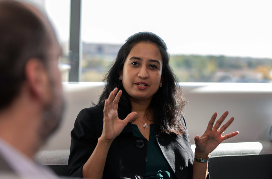 A profile of data scientists in deep conversation, with a woman in profile gesturing