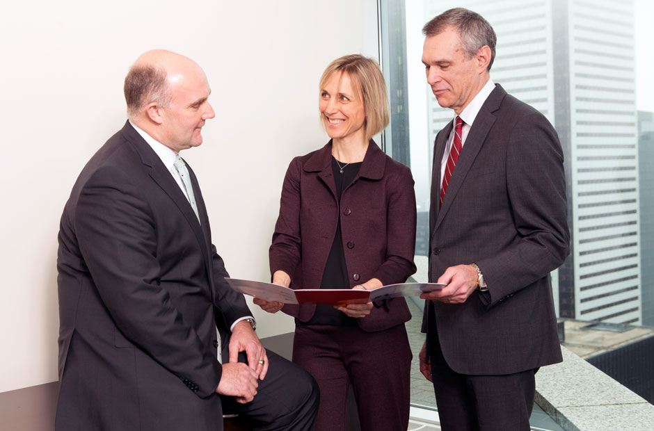 A trio of colleagues from RGA's Global Accounts team review a proposal in Toronto