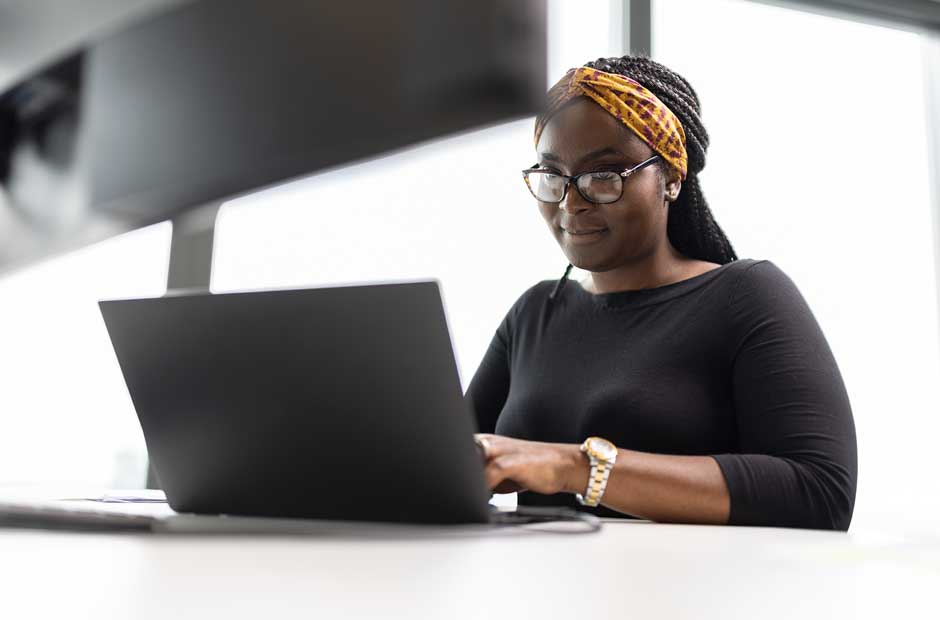 A diverse leader at RGA types on a computer in London