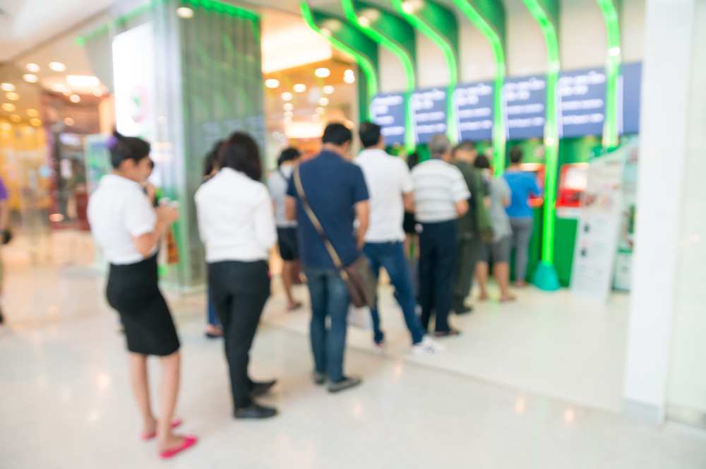 Asia banking; individuals lined up at an ATM