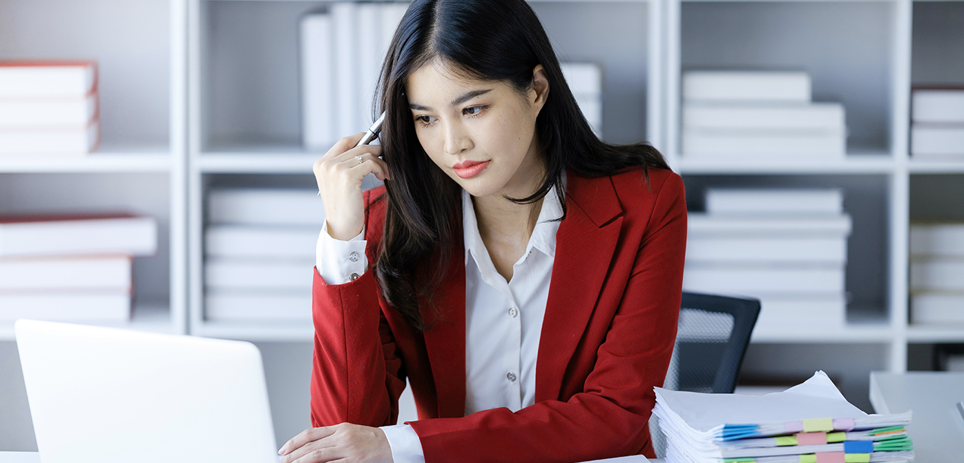 Woman in red blazer looking at computer