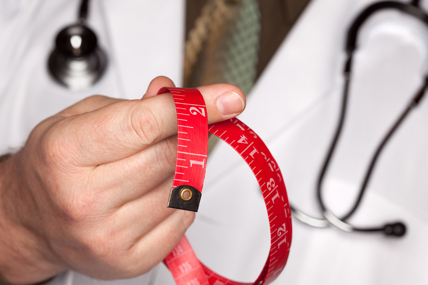 Doctor holding a red measuring tape