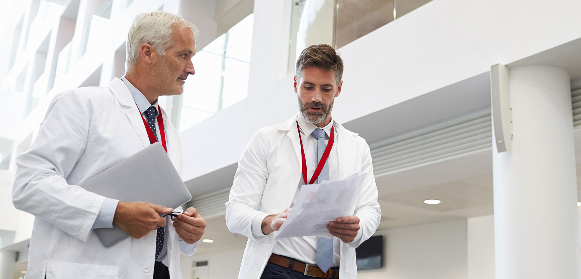 Two male doctors consulting each other as they walk