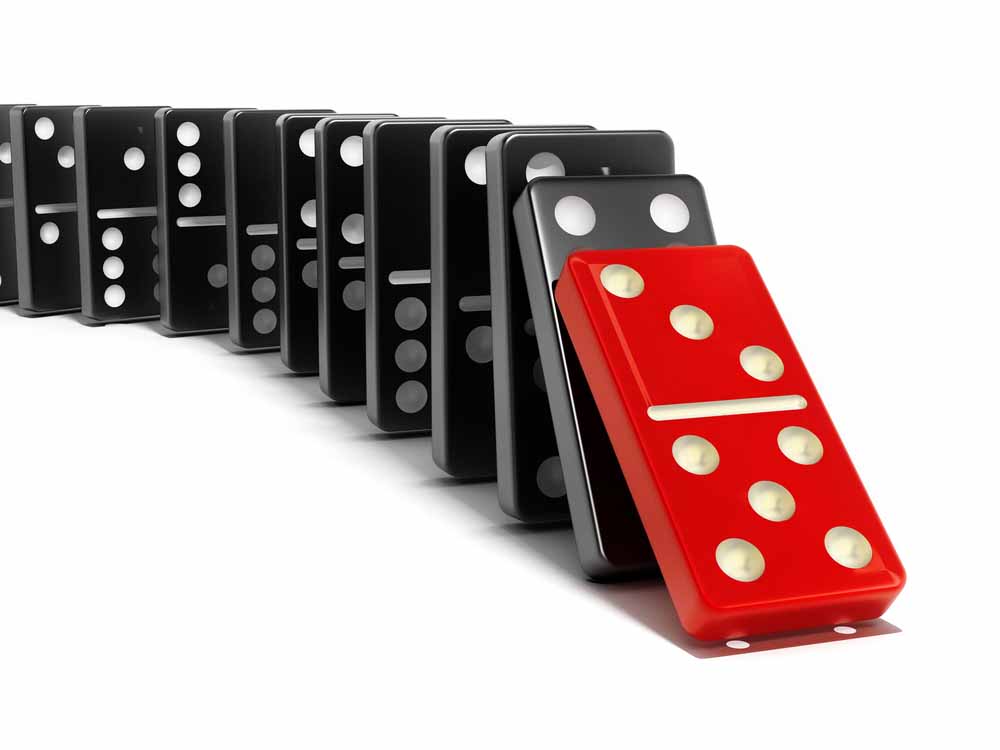 Red domino tipping rows of dominos