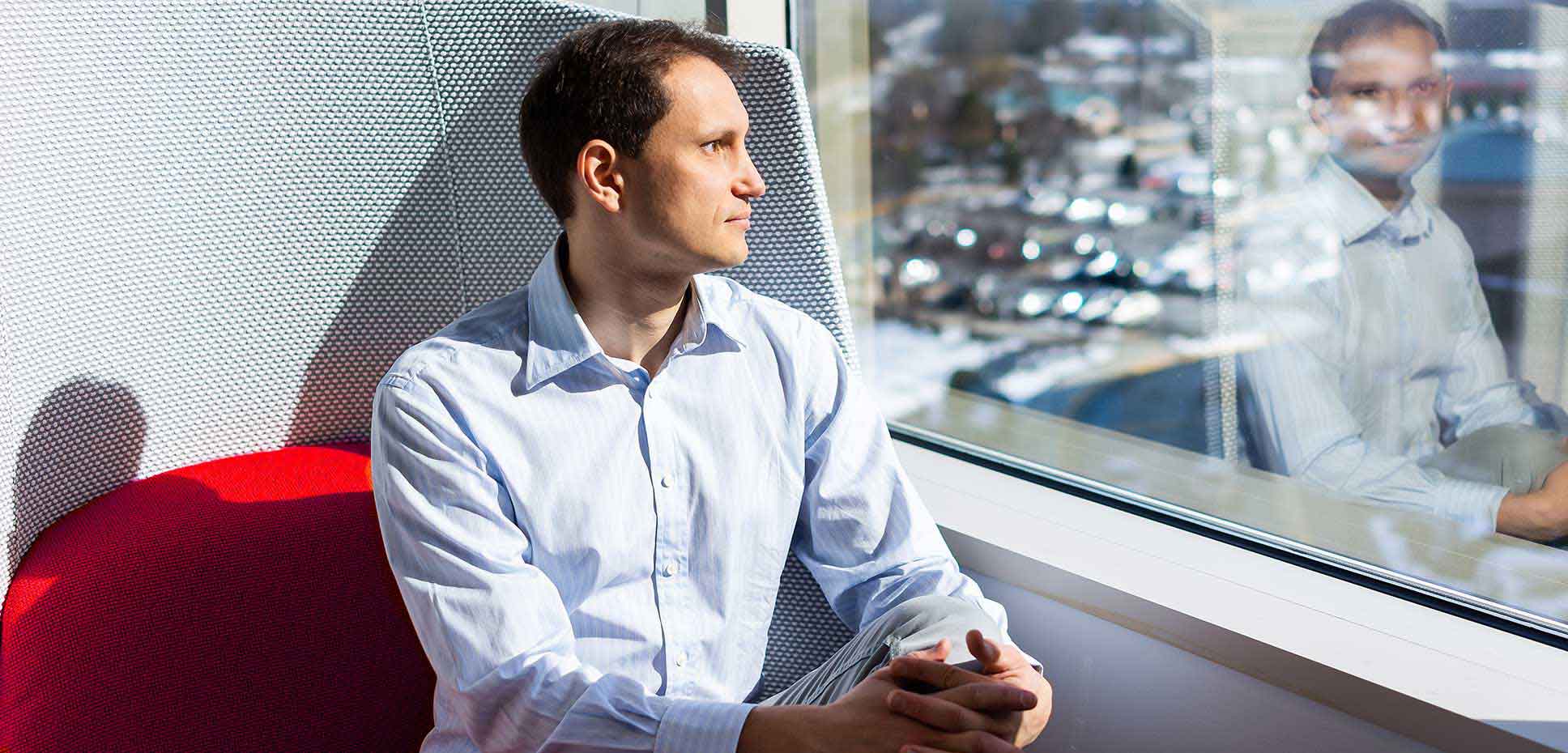 A man gazes contemplatively out of a window