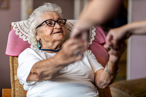 Elderly woman being helped up