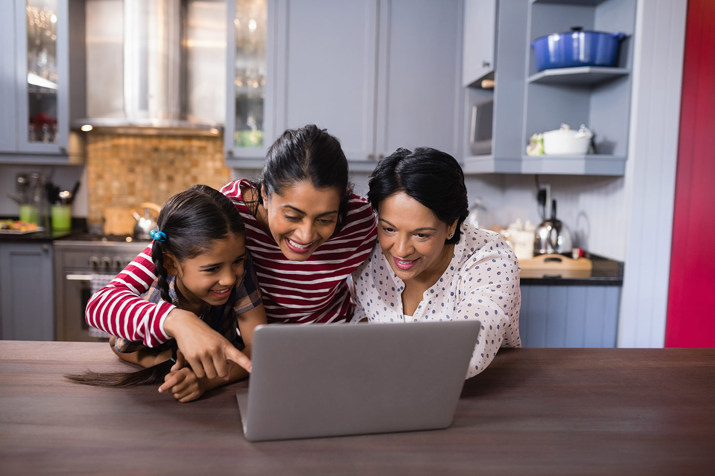 Family in the kitchen looking at a tablet
