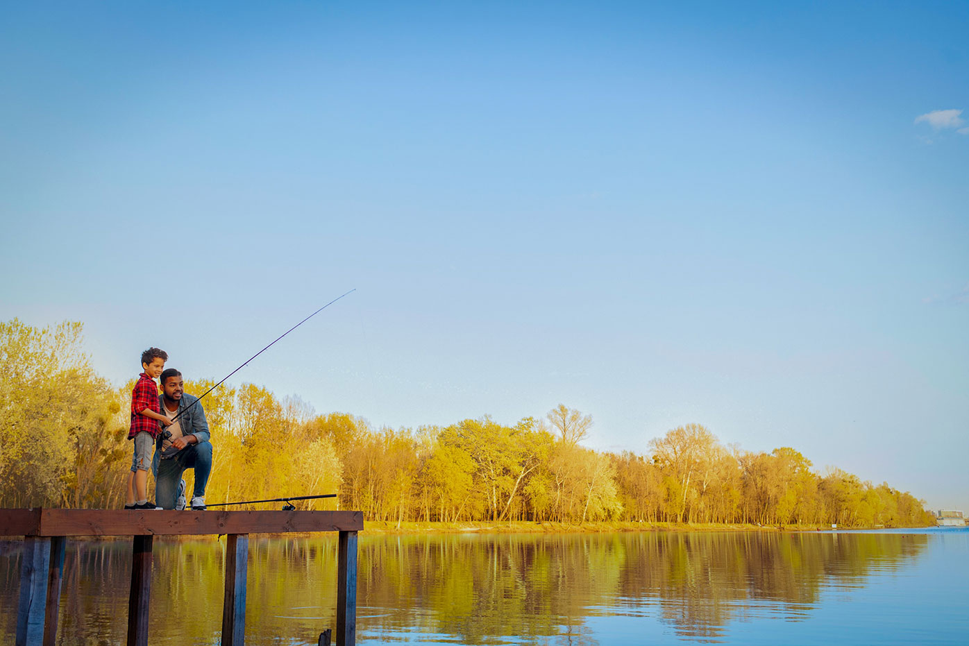 A father and son fishing on a dock
