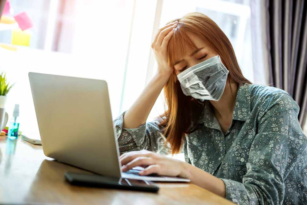 Asian woman, masked, displaying exhaustion