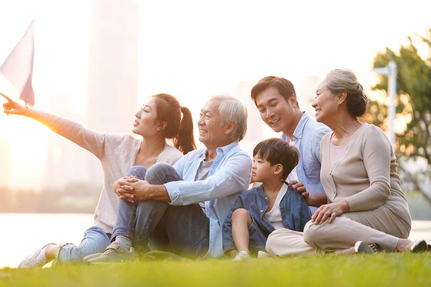 A multigenerational Asian family enjoys a park overlooking a river