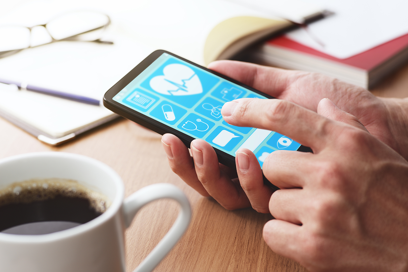 A man holds a smartphone displaying a healthcare application