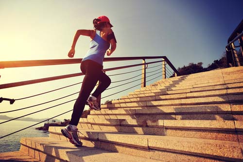 Female runner clambers up steps