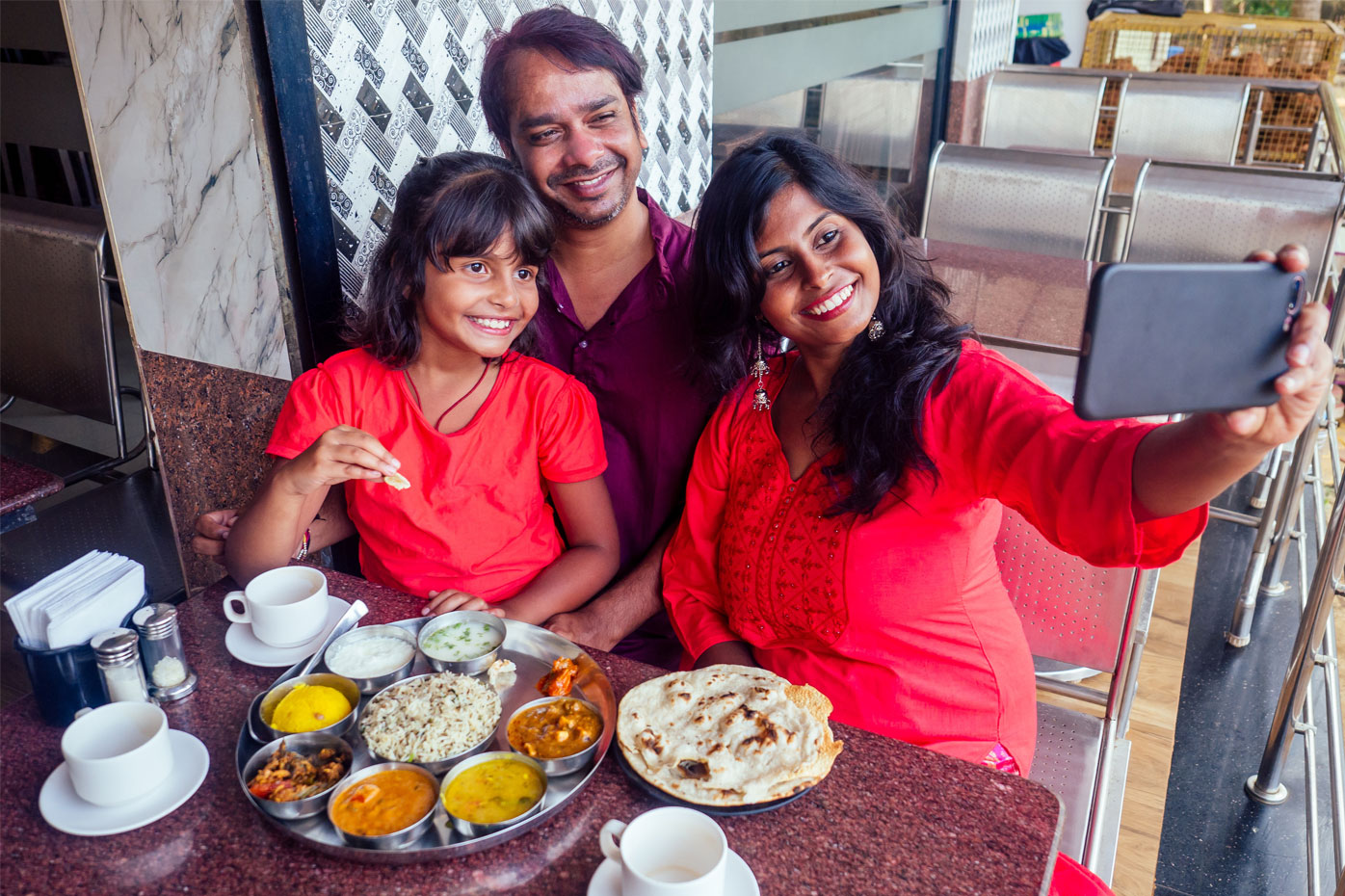 An Indian family pauses during their lunch to take a selfie photo