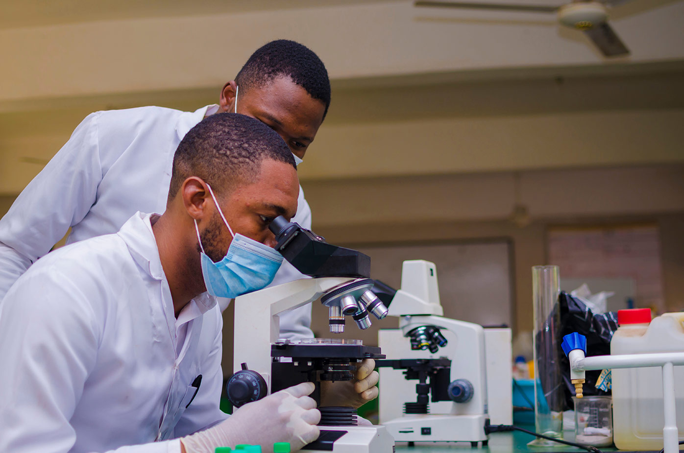 Lab technicians examing samples under a microscope