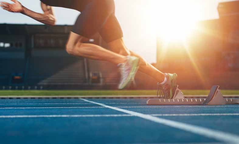 Sprinting runner jumps off the block