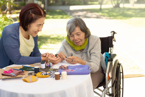 Image of elderly woman in a wheelchair with her caregiver