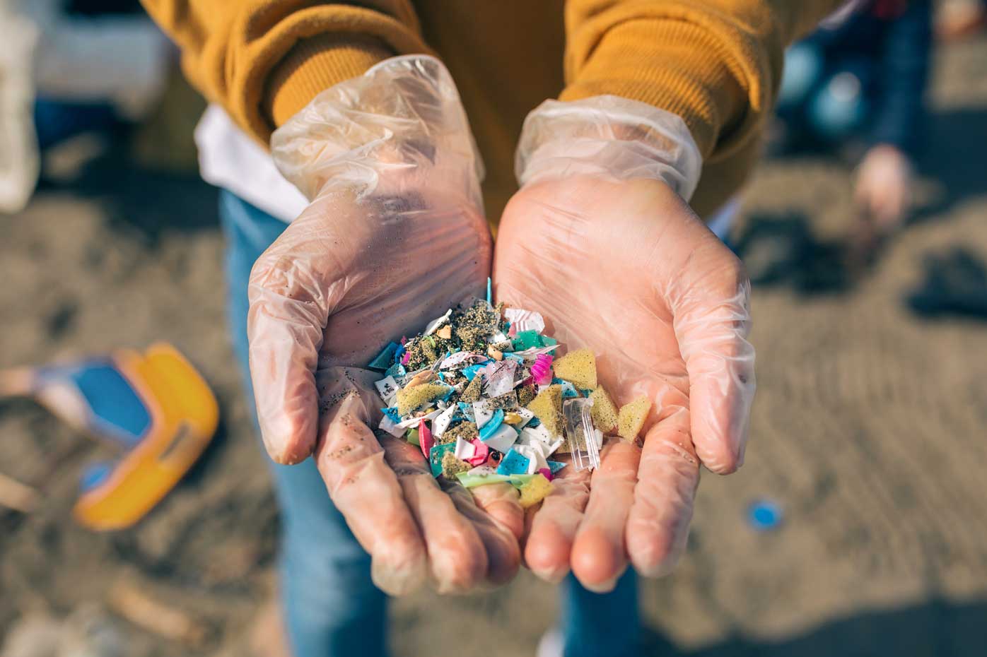 Cupped gloved hands holding microplastics