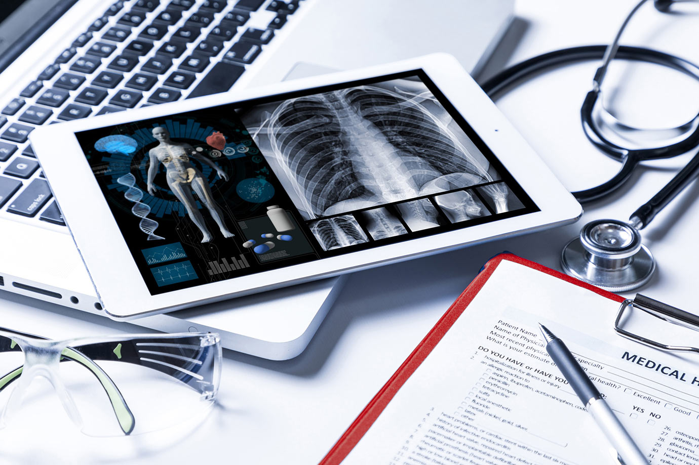 Tablet with x-rays on a table with other medical equipment