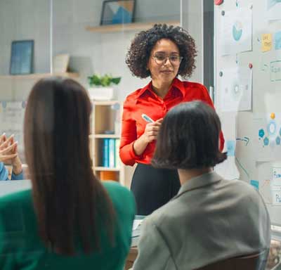 A woman in a red shirt leads a brainstorm