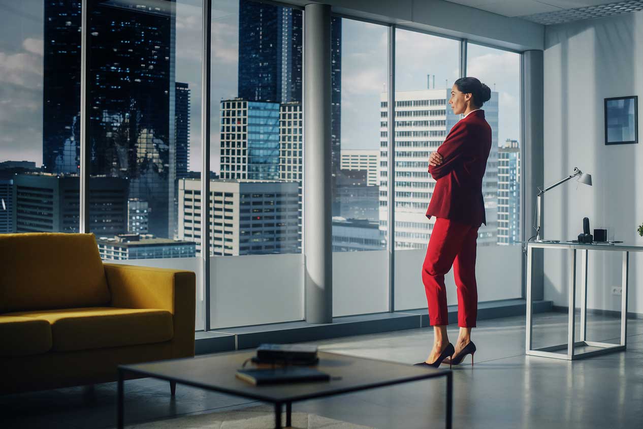 A red-suited woman gazes head at a cityscape