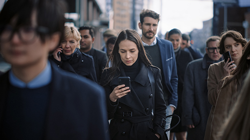 busy crowd with woman checking phone