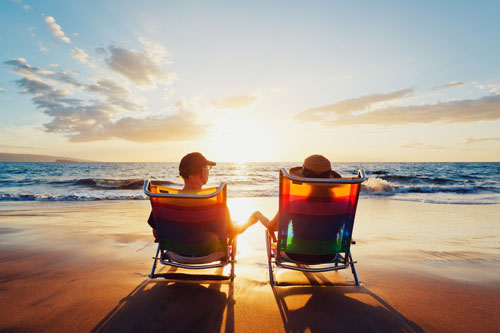 Two retirees relax on beach chairs