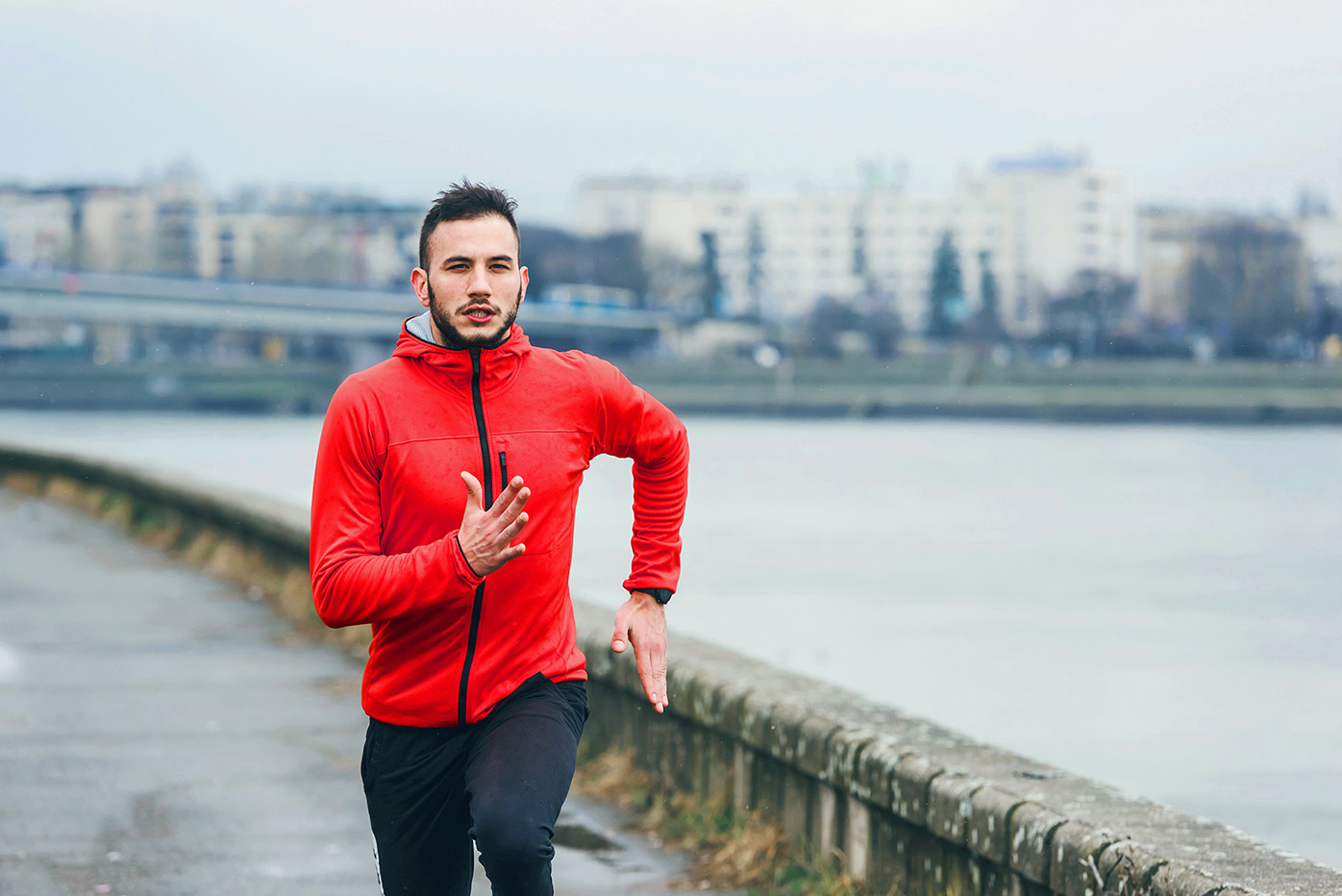 Man running along a city waterfront