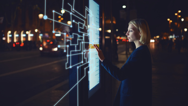 A woman gestures on an interactive dashboard 