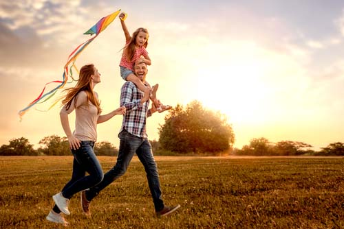 Family running in park with kite