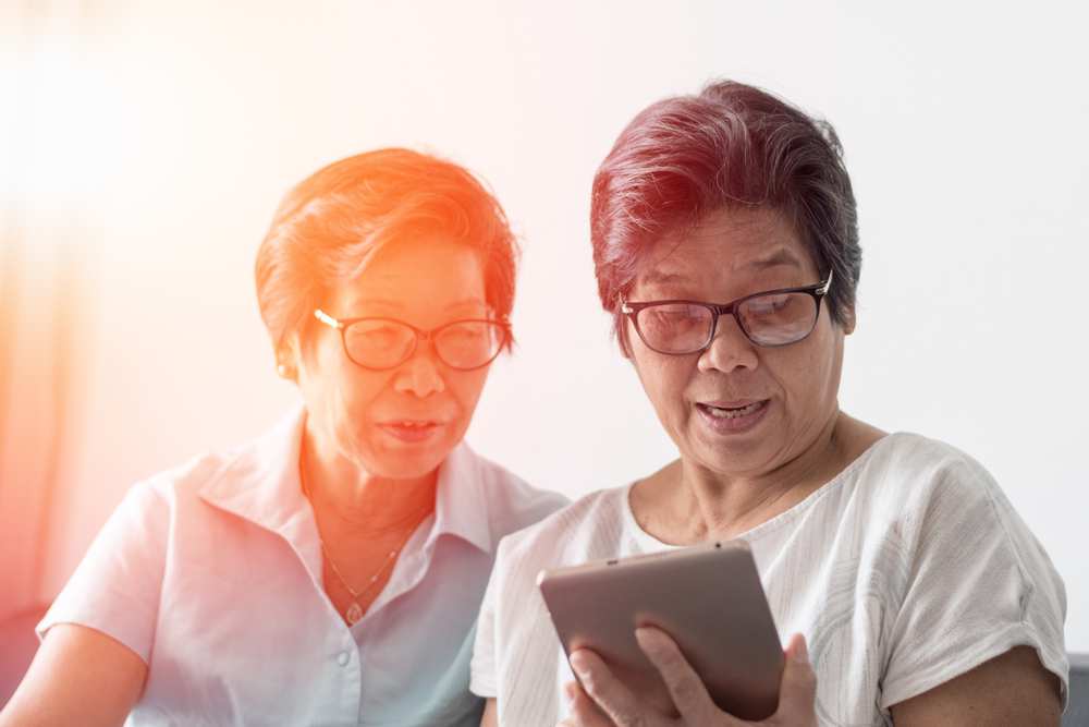 Aging Asia: Elderly sisters look at ipad