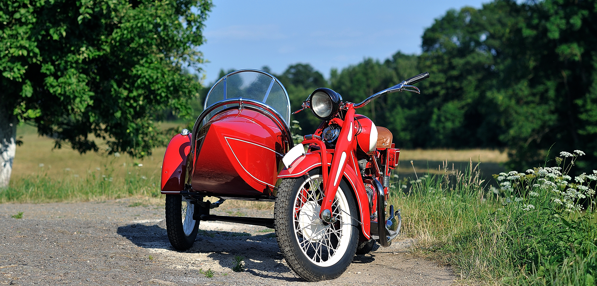 A bright red motorcycle sits parked next to a sidecar