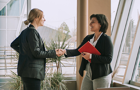 two women shaking hands